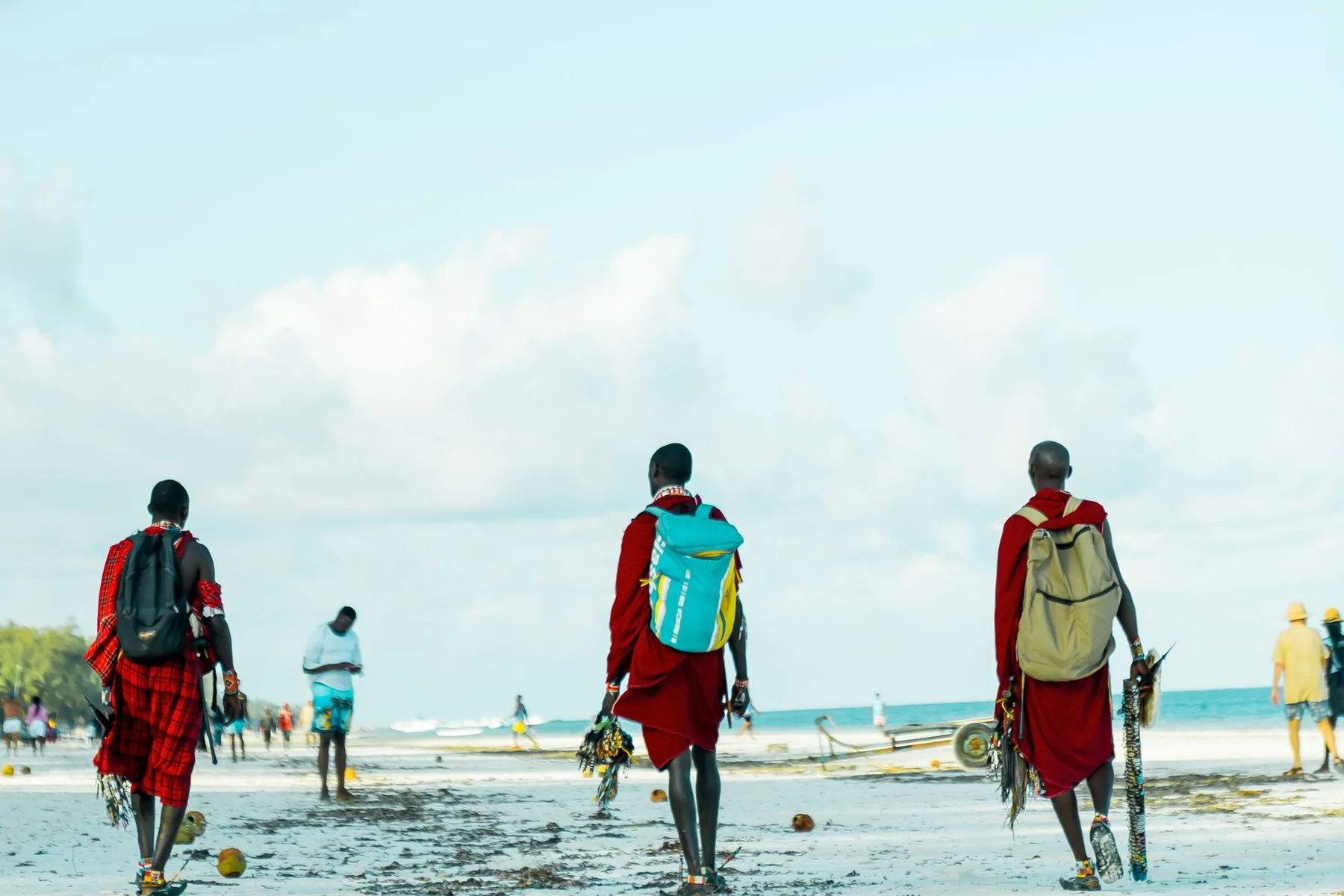 Maasai men walking the white sand of Diani Beach on Kenya's Indian Ocean coast
