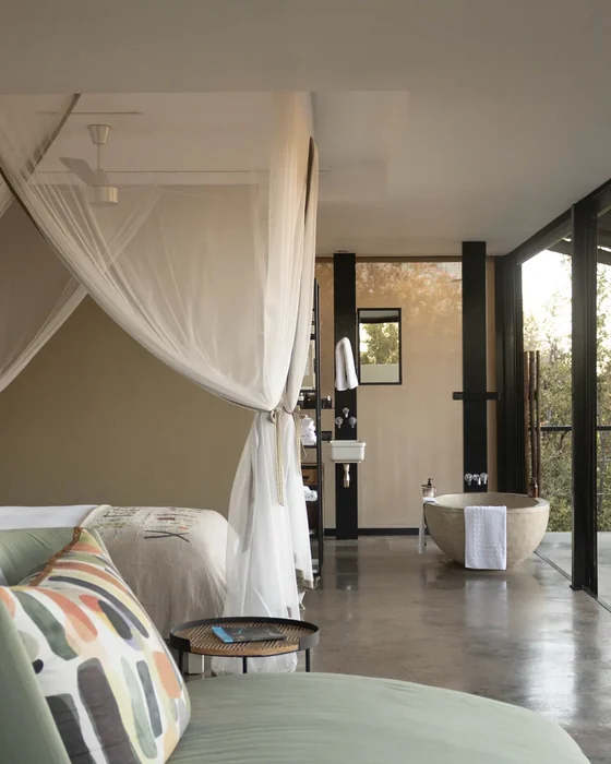 The interior of a romantic luxury safari tent with a canopied bed in Tanzania