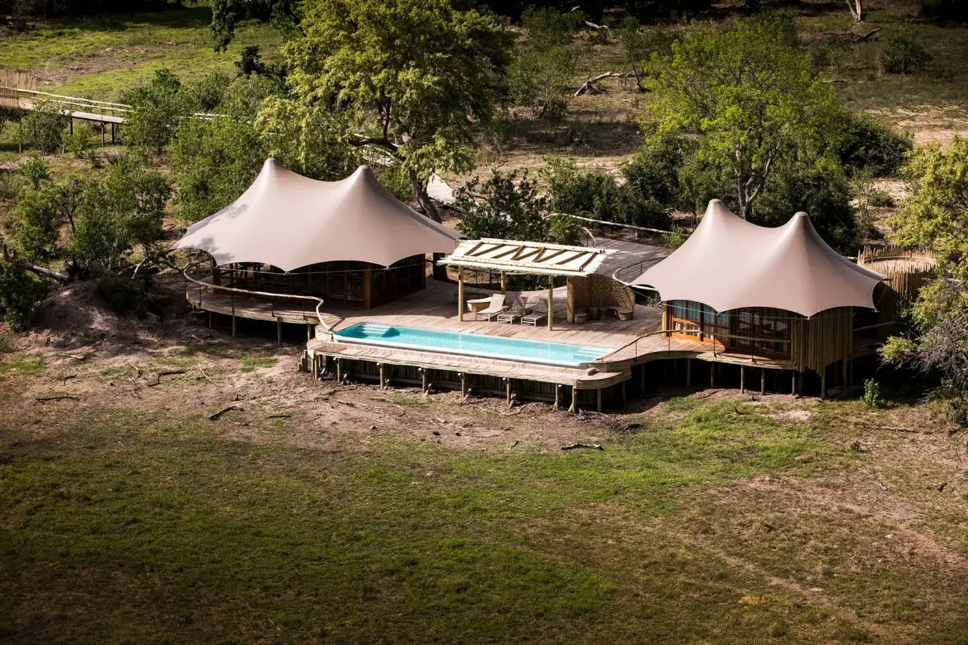 An aerial view of canvas pavilions and a pool deck at Mombo Camp in the Okavango Delta, Botswana