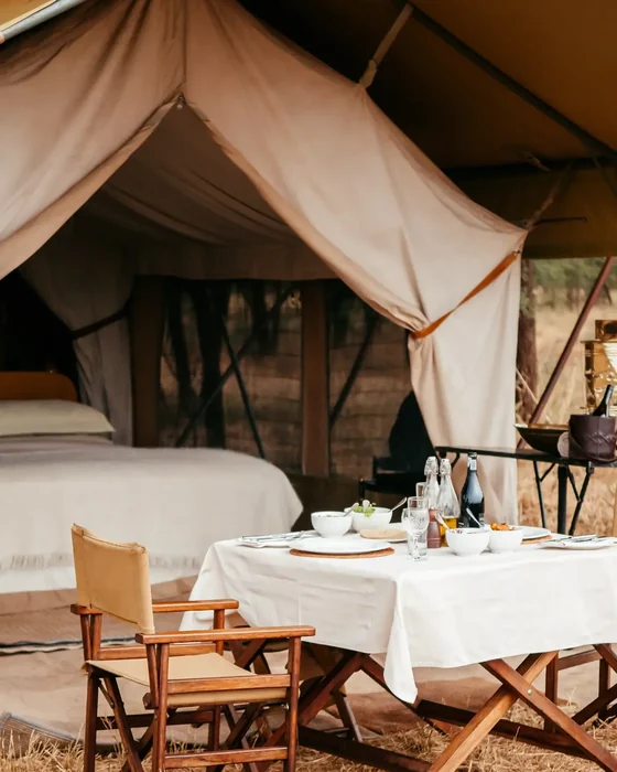 A luxury tented safari camp lit at dusk in the African bush