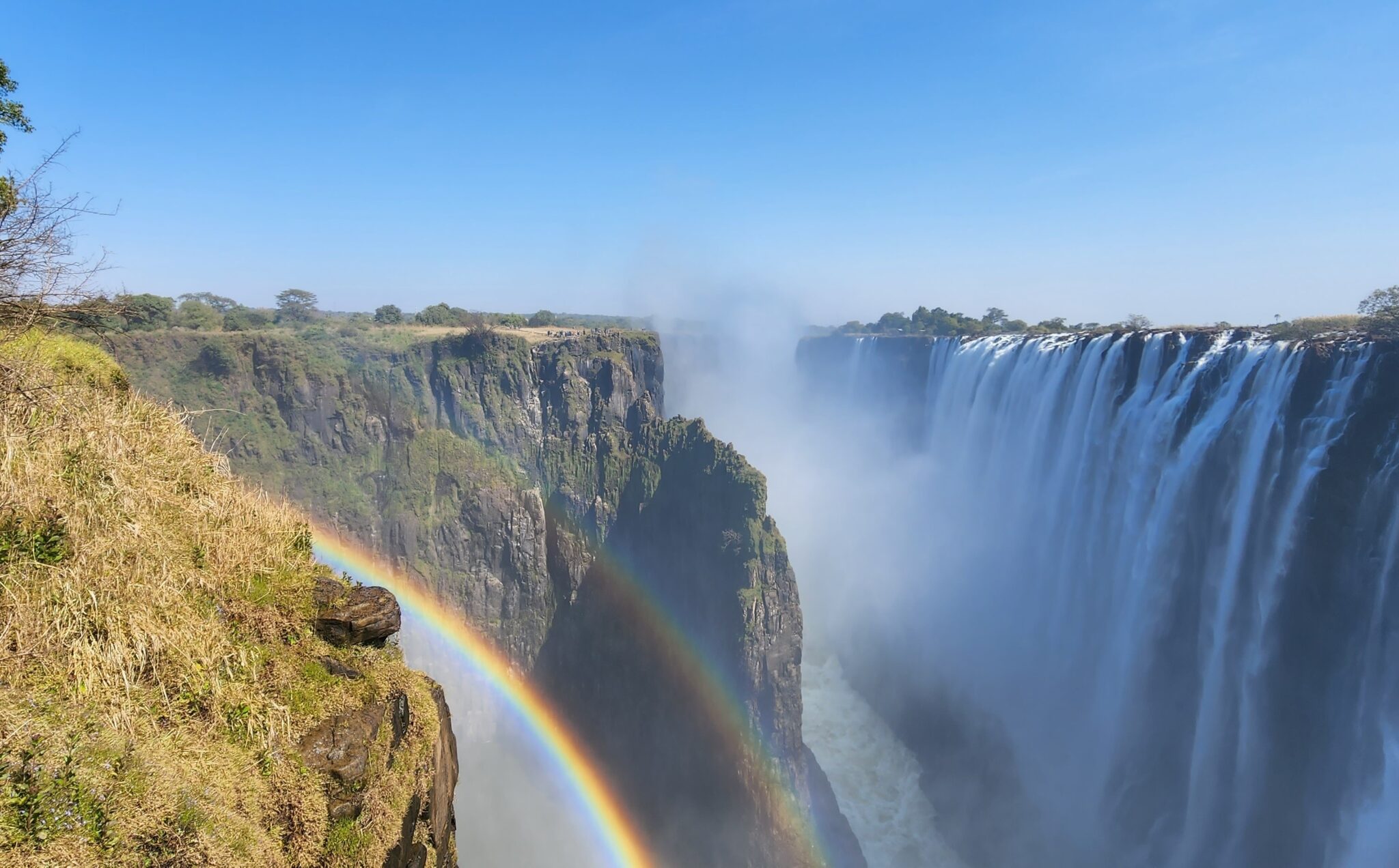 Breathtaking view of Victoria Falls with mist and rainbow on a luxury african safari