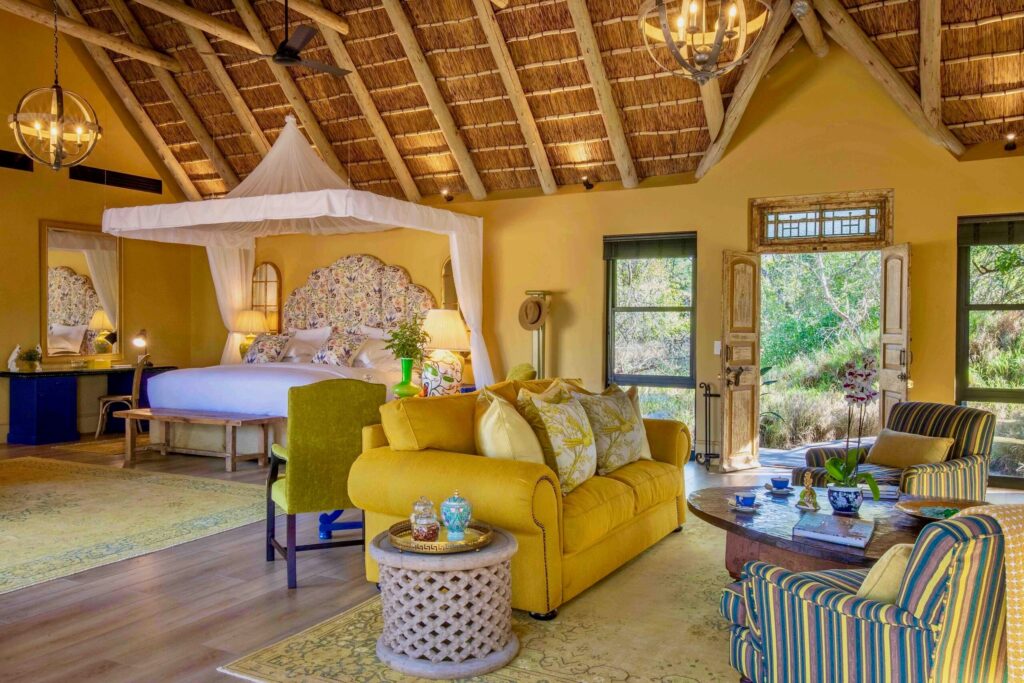 Interior of a luxurious suite at Royal Male Wane with elegant furnishings and views of the wilderness.